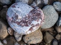 Herzförmiger Stein aus graublauem und dunkelrotem Konglomerat